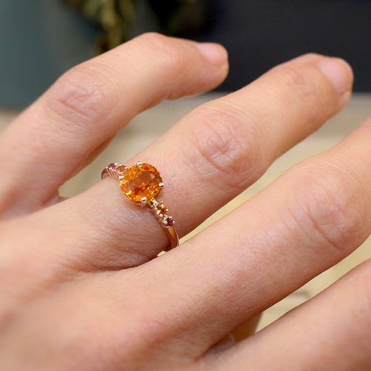 bague solitaire spessartite accompagne de rubis et de saphirs-monture en or rose