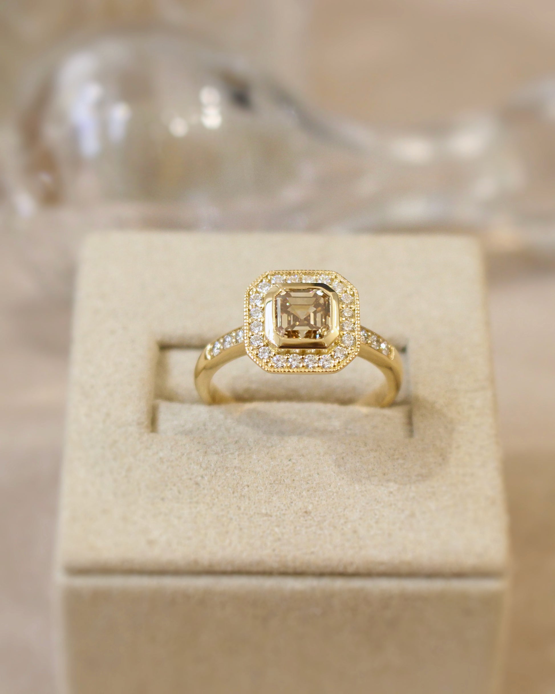 bague de demande en mariage ornée d'un diamant brun entouré de diamants sur une monture en or jaune