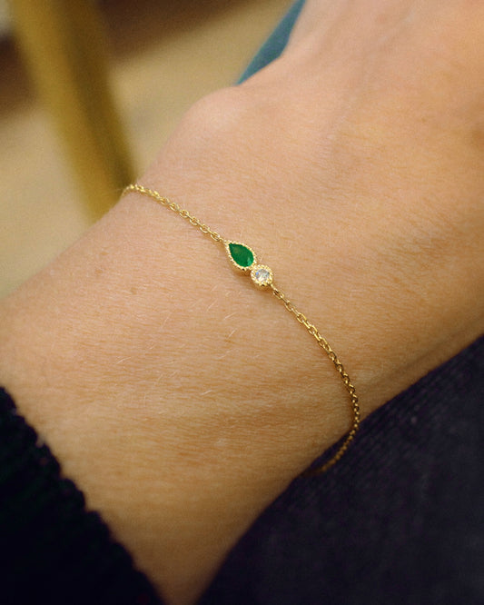 bracelet fin en or jaune orné d'une émeraude taille poire et d'un diamant taille brillant