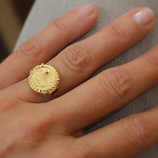 médaille amour sur bague en or jaune ornée d'un petit rubis